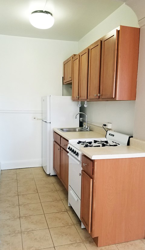 an empty kitchen with a stove and a refrigerator